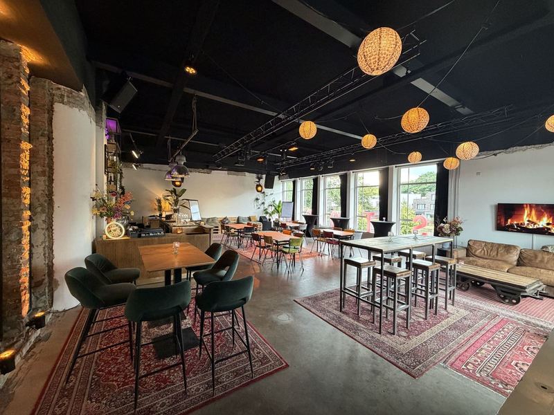 De bar en loungehoek in Het Lab bij STOOM Apeldoorn, met statafels en zitbanken