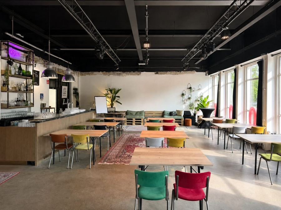 Het Lab bij STOOM Apeldoorn met losse werktafels verspreid door de ruimte en een whiteboard tegen de wand